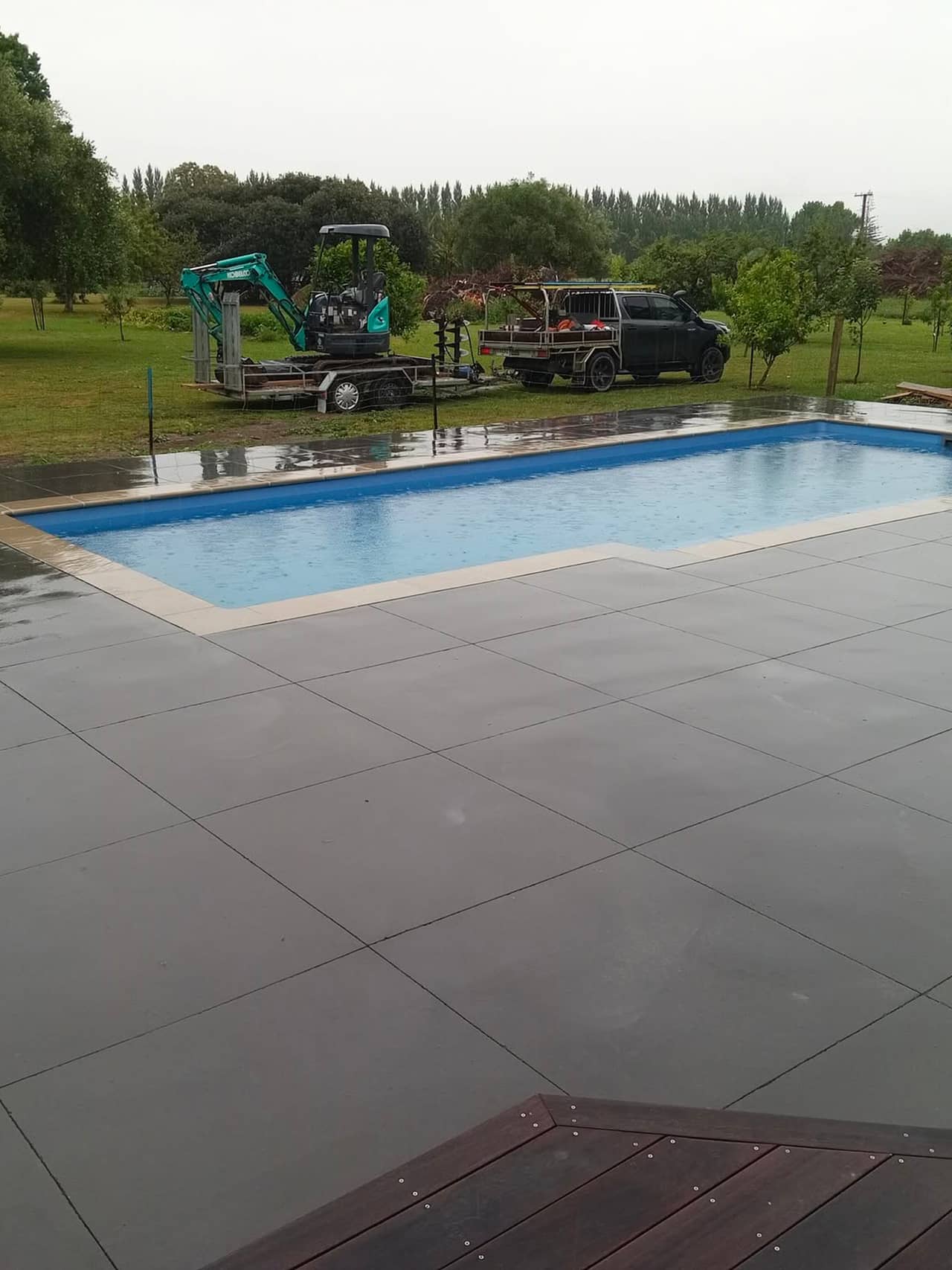 Charcoal paving around a pool on a rural Tairāwhiti property by Eastcrete Solutions